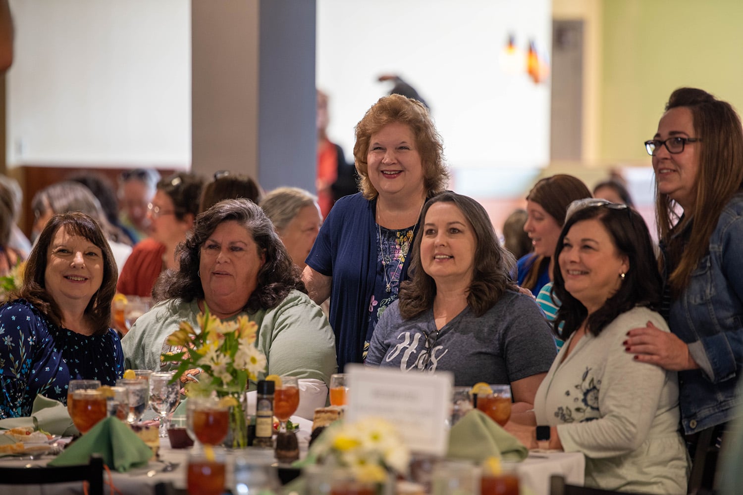 women pose for a photo around a table during the ladies luncheon