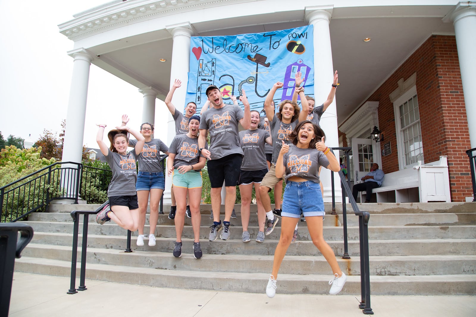 students jumping for joy in front of new student check-in during move in day 2019