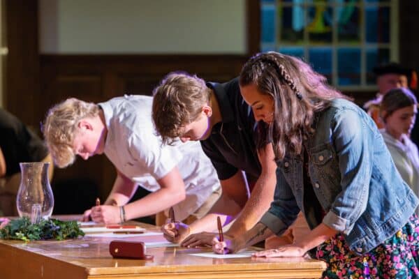 new students signing papers at new student matriculation in the chapel